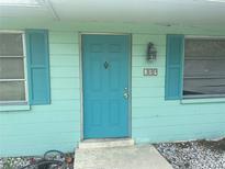 Inviting home entrance with a bright turquoise door and matching shutters on either side at 109 Colonia W Ln, Nokomis, FL 34275