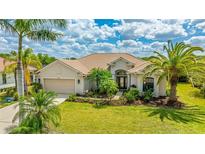 Inviting single-story home featuring a lush lawn, beautiful landscaping, and a two-car garage at 12822 Kite Dr, Bradenton, FL 34212