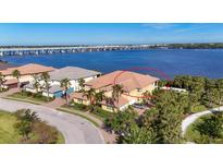 Stunning waterfront home with lush tropical landscaping and serene river views under a clear blue sky at 1294 Riverscape St # D, Bradenton, FL 34208