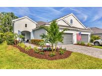 Charming single-Gathering home with a manicured lawn, paver driveway, and a two-car garage at 2628 Sapphire Blue Ln, Bradenton, FL 34211