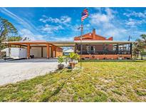 Inviting home showcasing an ample driveway, lush lawn, a large garage, and a charming screened-in porch at 280 W Cowles St, Englewood, FL 34223