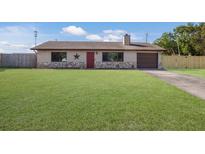 Charming single-story home featuring a well-maintained lawn, stone accents, and a red front door at 3123 40Th W Ave, Bradenton, FL 34205