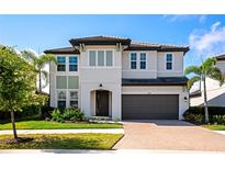 Two-story home boasts a two-car garage, tiled roof, well-maintained lawn, and professional landscaping at 4881 Antrim Dr, Sarasota, FL 34240