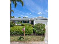 Charming single-story home with a manicured front yard, colorful landscaping, and a welcoming mailbox at 5523 Scotia Pl, Sarasota, FL 34231