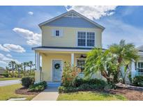 Inviting two-story home featuring a cozy front porch, lush tropical landscaping, and a bright, cheerful facade at 5532 River Sound Ter, Bradenton, FL 34208