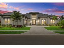 Stunning single-story home with a paver driveway, lush landscaping and modern architectural details at 9241 Starry Night Ave, Sarasota, FL 34241