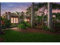 Charming home featuring a stucco exterior, red tile roof, and lush landscaping at 107 Nippino W Trl, Nokomis, FL 34275