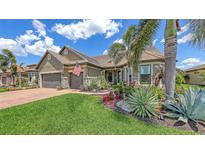 Beautiful home exterior featuring a lush landscaped yard, tile roof and a two-car garage at 11176 Roseate Ct, Sarasota, FL 34238