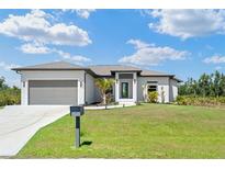 Beautiful one-story home featuring a well-manicured lawn and modern architectural details at 13552 Boatbill Ln, Port Charlotte, FL 33981