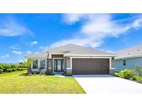Charming single-story home with a well-manicured lawn, a two-car garage, and inviting curb appeal at 16139 69Th E Ln, Parrish, FL 34219