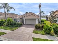 Charming single-story home featuring a beautiful tile roof, paver driveway, and well-manicured landscaping at 2212 Weaver Bird Ln, Venice, FL 34292