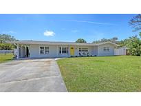 Charming single-story home with a well-manicured lawn and inviting yellow front door at 2220 Palm Ter, Sarasota, FL 34231