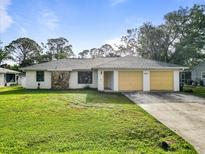 Charming single-story home with a well-maintained lawn, attached two-car garage, and neutral color palette at 2272 Palomar St, North Port, FL 34287
