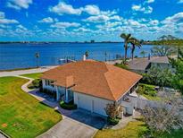 Waterfront home features a two-car garage, lush lawn, and stunning views of the water at 2305 Riverview Blvd, Bradenton, FL 34205