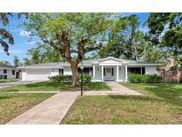 Charming one-story home features a well-manicured lawn, mature landscaping, and attached two-car garage at 320 25Th W St, Bradenton, FL 34205
