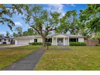 Charming home with mature trees, a well-manicured lawn, and a classic white facade at 320 25Th W St, Bradenton, FL 34205