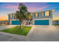 Charming two-story home with updated facade, blue garage doors and tropical landscaping at 3711 118Th W St, Bradenton, FL 34210