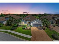 Beautiful single-Gathering home with a well-manicured lawn and a brick driveway at sunset at 4607 Benito Ct, Bradenton, FL 34211