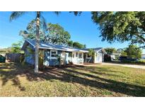 Charming single-story home featuring a well-manicured front yard and an attached garage with tropical landscaping at 8731 Peggy Ave, Sarasota, FL 34231