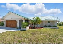 Charming home featuring an attached garage, arched front entry, and meticulous landscaping at 10616 Ayear Rd, Port Charlotte, FL 33981