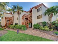 Beautiful condo building with lush landscaping and exterior stairs to upper units at 1500 Cove Ii Pl # 524, Sarasota, FL 34242