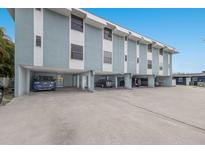 The exterior of this multilevel condo shows covered parking and easy access to residences above at 205 Highland Ave # 2, Bradenton Beach, FL 34217