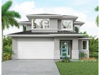 Modern two-story home featuring gray siding, stone accents, a two-car garage, and a bright blue front door at 2563 Loma Linda St, Sarasota, FL 34239