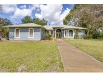 Charming one-story home with lush lawn, mature trees, and a welcoming entrance at 361 Whitfield Ave, Sarasota, FL 34243