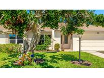 Charming home featuring a well-manicured lawn, mature tree, and inviting curb appeal at 4172 Oakhurst W Cir, Sarasota, FL 34233