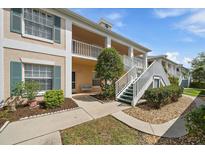 Inviting exterior view with manicured landscaping and white stairs leading to the second floor units at 4210 Caddie E Dr # 201, Bradenton, FL 34203