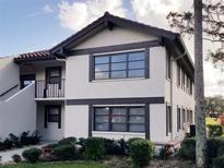 Two-story condo with brown trim, balcony, tidy landscaping, and a red tile roof on a sunny day at 5630 Golf Pointe Dr # 108, Sarasota, FL 34243