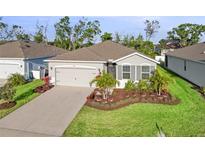 Lovely single-story home boasts a lush green lawn and a convenient two-car garage at 5727 Oak Bridge Ct, Bradenton, FL 34211