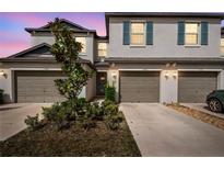 Townhome exterior with beige facade, matching garages, and manicured landscaping at 633 Royal Empress Dr, Ruskin, FL 33570