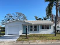 Charming single-story home featuring a well-kept lawn, attached garage, and light blue shutters at 3705 Chinaberry Rd, Bradenton, FL 34208
