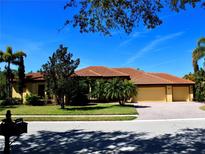 Beautiful single-story home with terra cotta roof, meticulously landscaped yard, and a two-car garage at 406 Petrel Trl, Bradenton, FL 34212