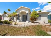 Charming single-story home with manicured landscaping, palm trees, and a welcoming columned front porch at 4219 Eastlake Ct, Port Charlotte, FL 33948