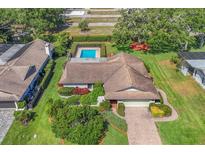 Beautiful home with lush landscaping, brick driveway, and screened pool at 4806 Huntleigh Dr, Sarasota, FL 34233