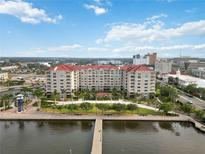Stunning aerial view of the condo building with waterfront access and city skyline at 808 3Rd W Ave # 203, Bradenton, FL 34205