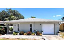 Charming single-story home featuring a one-car garage and a beautifully landscaped front yard with colorful flowers at 240 Patterson Ave, Osprey, FL 34229