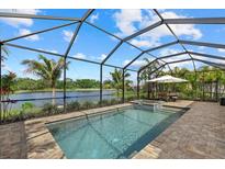 Screened pool with a built-in spa surrounded by brick pavers with a beautiful lake view at 2818 Starwood Ct, Lakewood Ranch, FL 34211