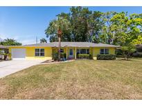 Charming yellow single-story home featuring a well-manicured lawn and a mature palm tree in the front yard at 337 Somerset Ave, Sarasota, FL 34243