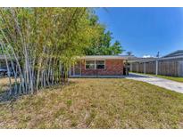 Charming brick home with carport and mature bamboo landscaping in the front yard at 3545 Lalani Blvd, Sarasota, FL 34232
