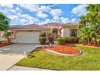 Charming single-story home featuring a well-manicured lawn, lush landscaping, and a tile roof at 4173 Westbourne Cir, Sarasota, FL 34238