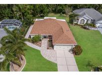 Inviting home featuring a new roof, attached two-car garage, lush lawn, and a screened-in pool at 4211 73Rd E Ter, Sarasota, FL 34243