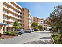 Condo building exterior showcasing convenient parking spaces and well-maintained landscaping at 4570 Pinebrook Cir # 406, Bradenton, FL 34209