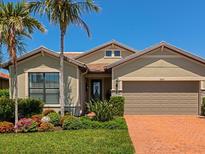 Charming home with manicured lawn, lush landscaping, brick driveway and two-car garage at 5952 Snowy Egret Dr, Sarasota, FL 34238