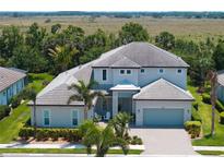 Two-story home boasts a meticulously landscaped front yard and a covered entrance, enhancing its curb appeal at 6317 Rivo Lakes Blvd, Sarasota, FL 34241