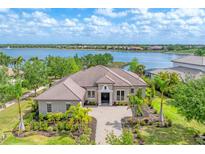 Stunning waterfront home with lush landscaping and a paver driveway, offering luxury and curb appeal at 7643 Haddington Cv, Bradenton, FL 34202