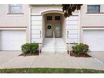Inviting townhome entrance featuring a well-maintained walkway, landscaping, and unit numbers above each front door at 6314 Bay Cedar Ln # 201, Bradenton, FL 34203