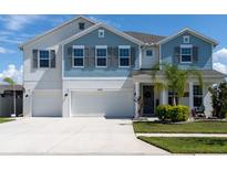 Charming two-story home with a three-car garage and a well-manicured lawn at 11702 Tetrafin Dr, Riverview, FL 33579